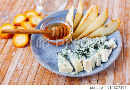 Roncari blue cheese served on plate with pear, croutons and honey 114827363