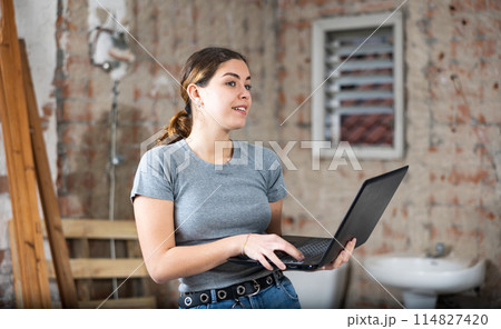 Woman with laptop on indoor construction site 114827420