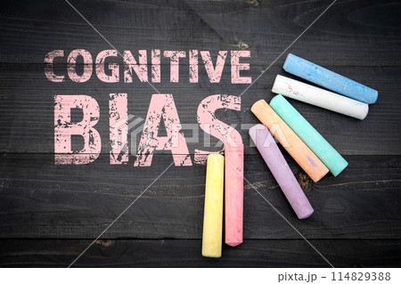Cognitive Bias. Text and pieces of chalk on a dark wood texture background Cognitive Bias. Text and pieces of chalk on a dark wood texture background 114829388