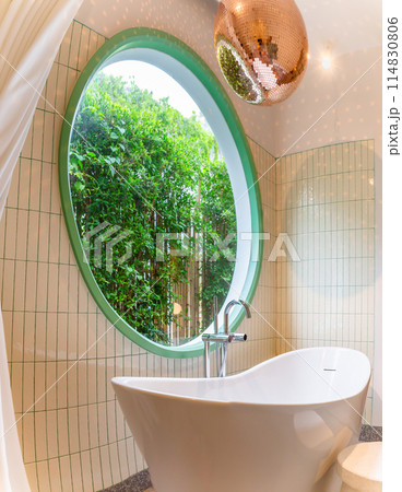 White bathtub with hot water faucet Silvery evening with circular windows and trees in the background and disco balls on the ceiling. White bathtub with hot water faucet Silvery evening with circular windows and trees in the background and disco balls on the ceiling. 114830806