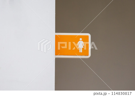 Orange female or woman toilet sign on the wall. copy space background Orange female or woman toilet sign on the wall. copy space background 114830817