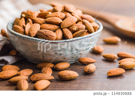 Peeled almond nuts in bowl on wooden table. Peeled almond nuts in bowl on wooden table. 114830888