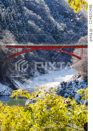 雪が残る湖畔の谷間に架かる赤い橋 雪が残る湖畔の谷間に架かる赤い橋 114831486