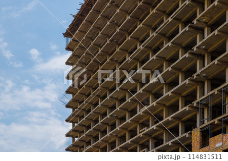 High-rise apartment building under construction against a blue sky with simple urban design High-rise apartment building under construction against a blue sky with simple urban design 114831511