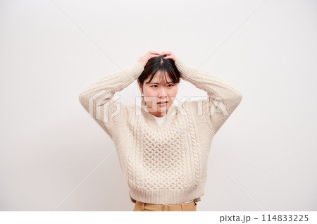 頭を抱える女性　白背景　悩む　考える 114833225