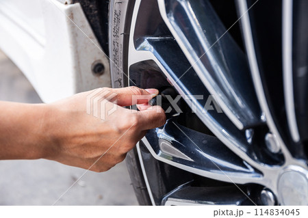 Close-Up Of Hand Open the air plug for car tyre pressure measurement 114834045