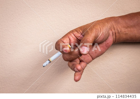Close-up of a man's hand working hard smoking a cigarette with smoke. Background texture 114834435