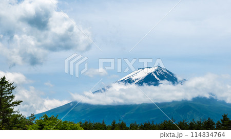 The snowy and cloudy peak of Mount Fuji is a symbol of Japan and a popular tourist destination. Copy space background The snowy and cloudy peak of Mount Fuji is a symbol of Japan and a popular tourist destination. Copy space background 114834764