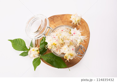 Tincture of horse chestnut flowers in a jar. Homemade herbal tincture. Hair treatment concept. Flat lay 114835432