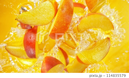 Freeze Motion of Flying Peaches Slices into Water, Colored Background. 114835579