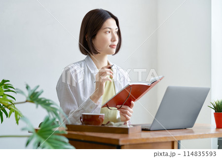 部屋でパソコンを操作する若い女性 114835593