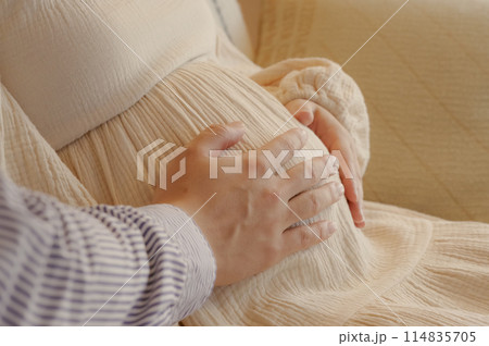 お腹の赤ちゃんをなでる夫婦 お腹の赤ちゃんをなでる夫婦 114835705