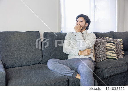 ソファーに座るり考える男性 114838521
