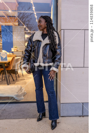 Stylish Woman in Leather Jacket Outside Modern Caf 114839868
