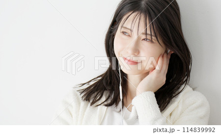 ベッドで音楽を聞く女性	 114839992