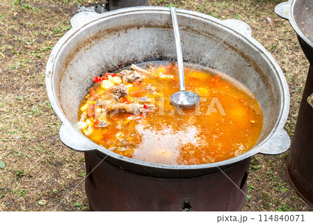 Cooking in a large cauldron Oriental dishes - soup. Soup with large vegetables and meat. Shurpa in a large cauldron Cooking in a large cauldron Oriental dishes - soup. Soup with large vegetables and meat. Shurpa in a large cauldron 114840071