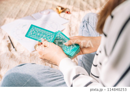 Lady shuffling tarot cards with green cover Lady shuffling tarot cards with green cover 114840253