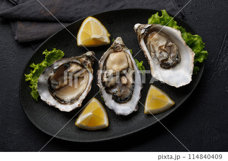 Fresh oysters with lemon on plate 114840409