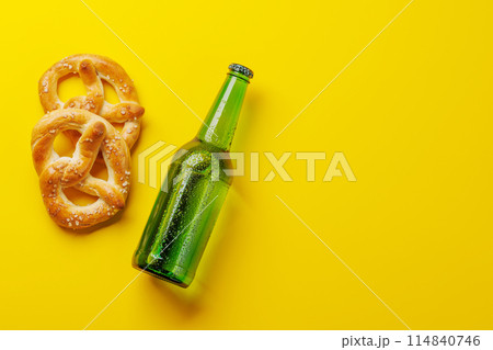 Beer bottle and pretzels on yellow background Beer bottle and pretzels on yellow background 114840746