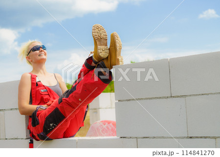 Woman taking break on construction site Woman taking break on construction site 114841270