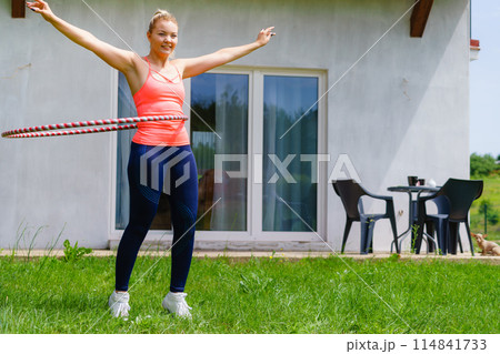 Young woman with hoola hoop outdoors 114841733