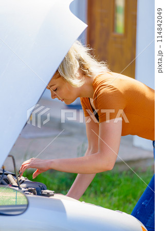 Woman standing near broken down car Woman standing near broken down car 114842049