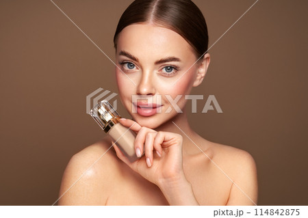 Portrait beautiful young woman with foundation bottle 114842875
