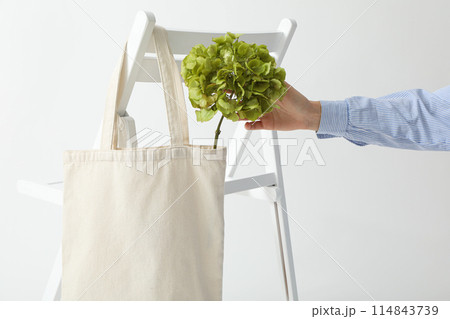A white bag hangs on a white chair 114843739