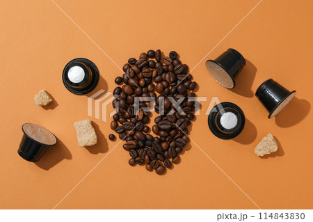 Coffee capsules, coffee beans and sugar on brown background, top view 114843830