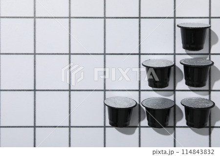 Black coffee capsules on light background, space for text 114843832