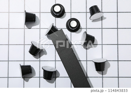 Black coffee capsules and box on light background, top view 114843833