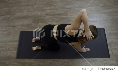 A woman from a knee elbow position making the bends of the body. Media. Concept of sport and body care. A woman from a knee elbow position making the bends of the body. Media. Concept of sport and body care. 114848537