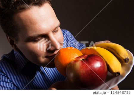 Diet nutrition. Happy young man smelling fruits. Diet nutrition. Happy young man smelling fruits. 114848735