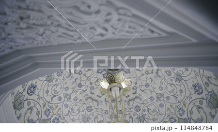 Interior design of mosque with carved walls and blue and white flowers on the ceiling. Scene. Concept of religion and architecture. 114848784