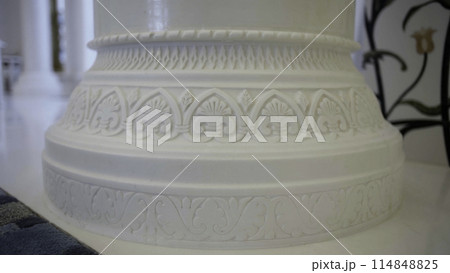Close up of white beautiful pillar with carved pattern. Scene. Interior details of a white mosque. Close up of white beautiful pillar with carved pattern. Scene. Interior details of a white mosque. 114848825