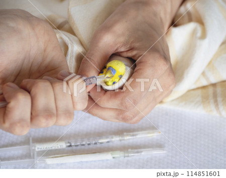 Veterinarian treats parrot bird and gives him medicine through a syringe. Veterinarian treats parrot bird and gives him medicine through a syringe. 114851601