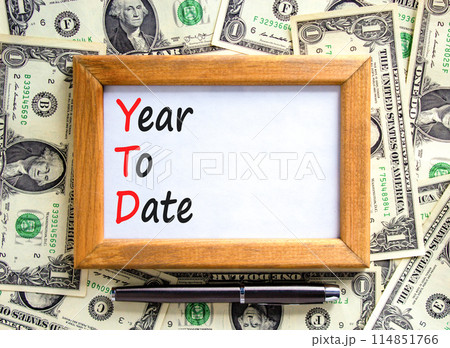 YTD year to date symbol. Concept words YTD year to date on beautiful wooden frame. Beautiful dollar bills background. Business YTD year to date concept. Copy space. 114851766