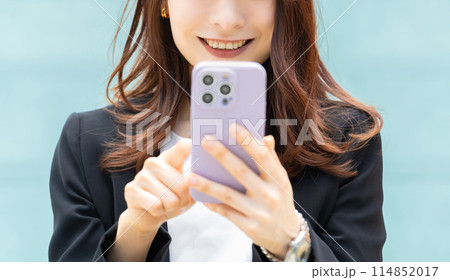 スマートフォンを操作をする笑顔のビジネスウーマン 114852017