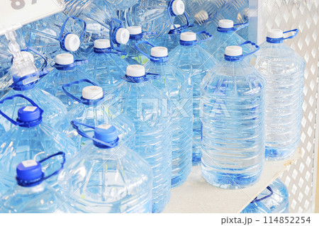 A collection of water bottles is neatly displayed on a shelf A collection of water bottles is neatly displayed on a shelf 114852254