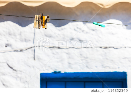 Wooden clothes pegs on a string outdoor 114852549