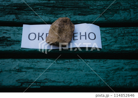 A piece of paper with the inscription painted on the bench 114852646