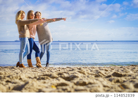 Three fashionable models pointing outdoor Three fashionable models pointing outdoor 114852839