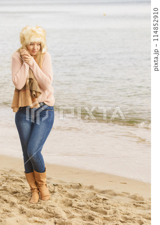Woman in stylish outfit feeling cold by the sea Woman in stylish outfit feeling cold by the sea 114852910
