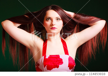 Long haired woman creating coiffure. 114853010
