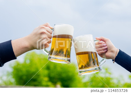 Man and woman clinking beer glasses with beer glasses. Man and woman clinking beer glasses with beer glasses. 114853726