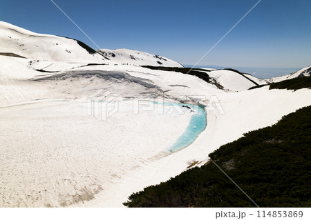 空撮5月残雪の立山室堂平の融解始まるミクリガ池青い水たまりと残雪と散策人々 114853869