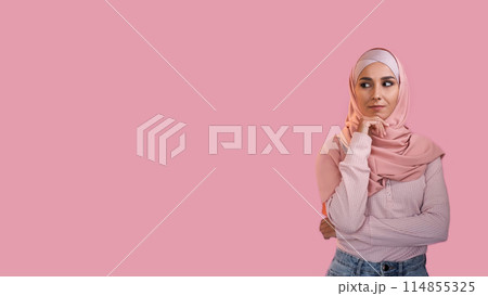 Curious woman. Advertising background. Pensive interested girl in hijab thinking considering offer isolated on pink empty space. Curious woman. Advertising background. Pensive interested girl in hijab thinking considering offer isolated on pink empty space. 114855325