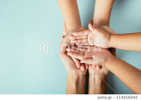 Top view studio shot of family hands stack isolated background. Parents and kid hold empty space symbolizing support and love for Family and Parents Day. Top view studio shot of family hands stack isolated background. Parents and kid hold empty space symbolizing support and love for Family and Parents Day. 114856848