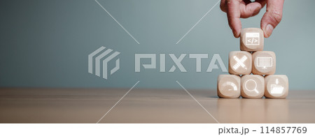 Web design and development concept, Hand holding wooden block on desk with web coding, design, coding, testing, web analytics and content management icon on virtual screen. Web design and development concept, Hand holding wooden block on desk with web coding, design, coding, testing, web analytics and content management icon on virtual screen. 114857769