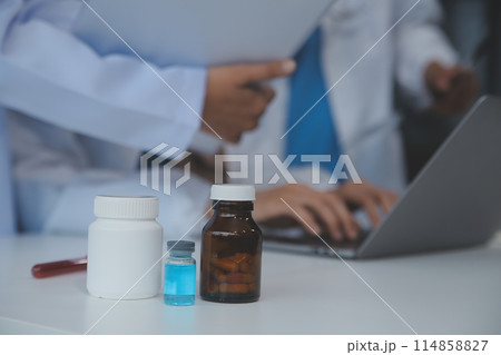 Doctor discussing diagnosis during the meeting. Group of doctor discussing work matter in the office at work. The medical team discusses treatment options with the patient. 114858827